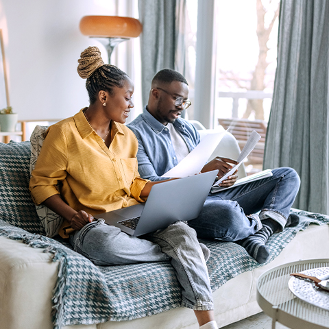 couple going through documents on their couch_480x480